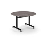 Round table with grey wood-effect top and metal legs with wheels on a white background