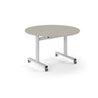 Round table with light grey top and  metal legs with wheels on a white background