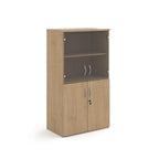 Office storage cupboard with a wood-effect carcass, lockable lower doors, and upper glass display doors with internal shelving, shown on a white background.