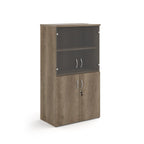 Office storage cupboard with a wood-effect carcass, lockable lower doors, and upper glass display doors with internal shelving, shown on a white background.