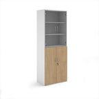 Tall office storage cupboard with a white carcass, lockable lower wood-effect doors, and upper glass display doors with internal shelving, shown on a white background.