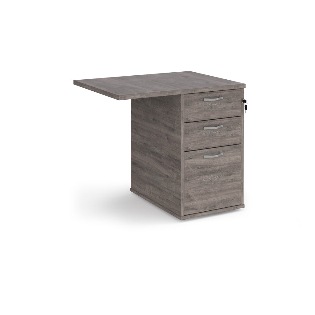 Desk extension with a grey wood-effect finish, integrated three-drawer pedestal, shown on a white background.