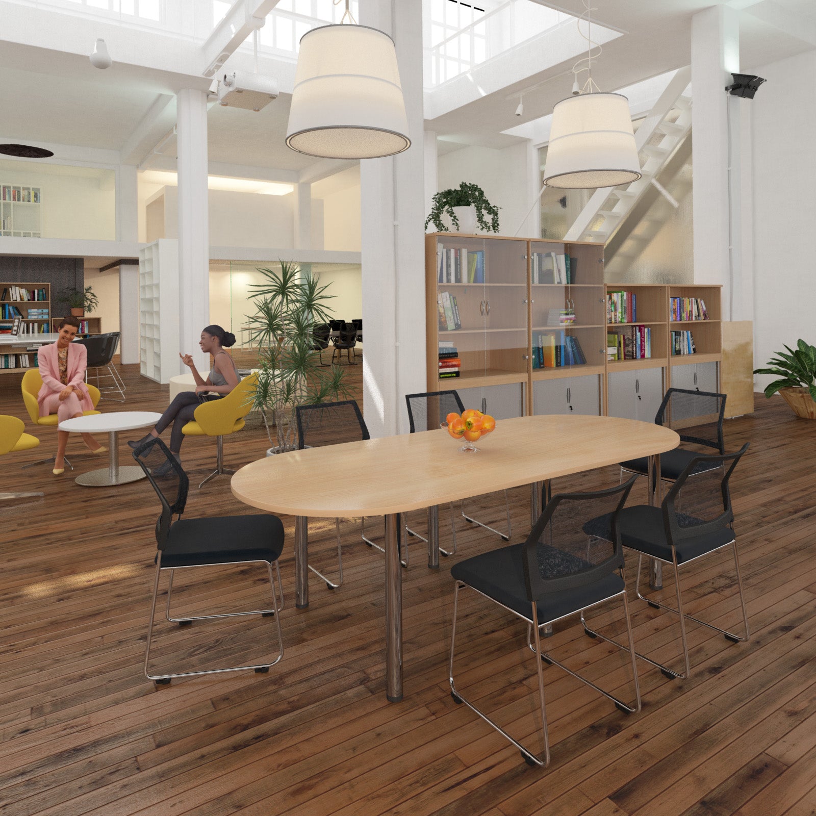 Modern office space with a long wooden table and chairs, bookshelves, and people working.