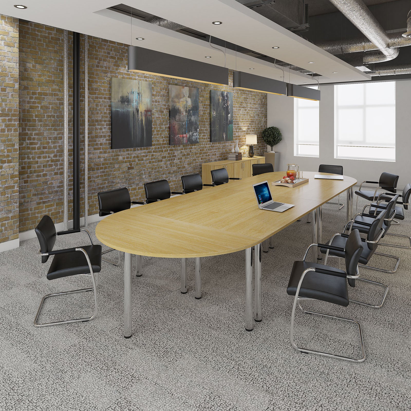 Modern conference room with a long wooden table and black chairs against a brick wall.