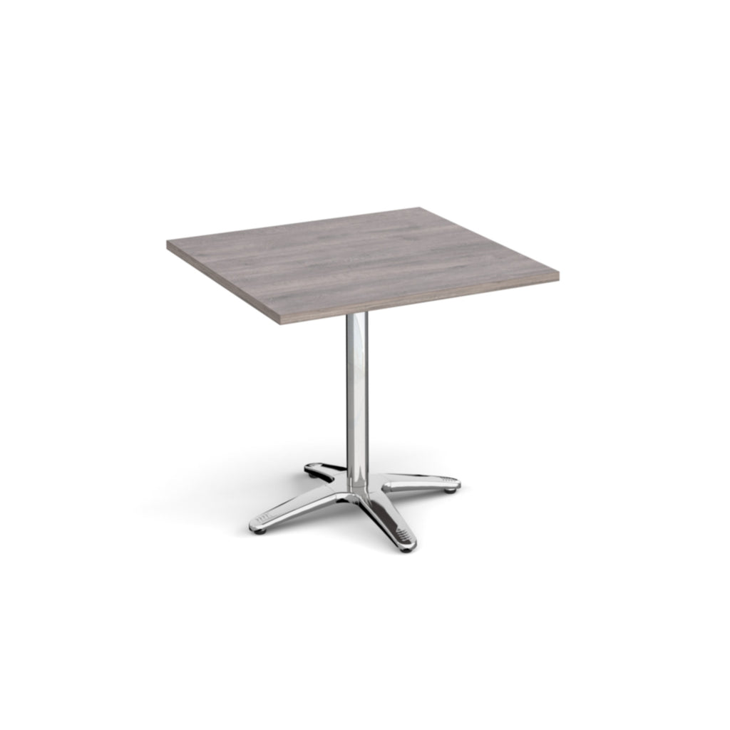 Square table with a grey wood-effect top and chrome base on a white background