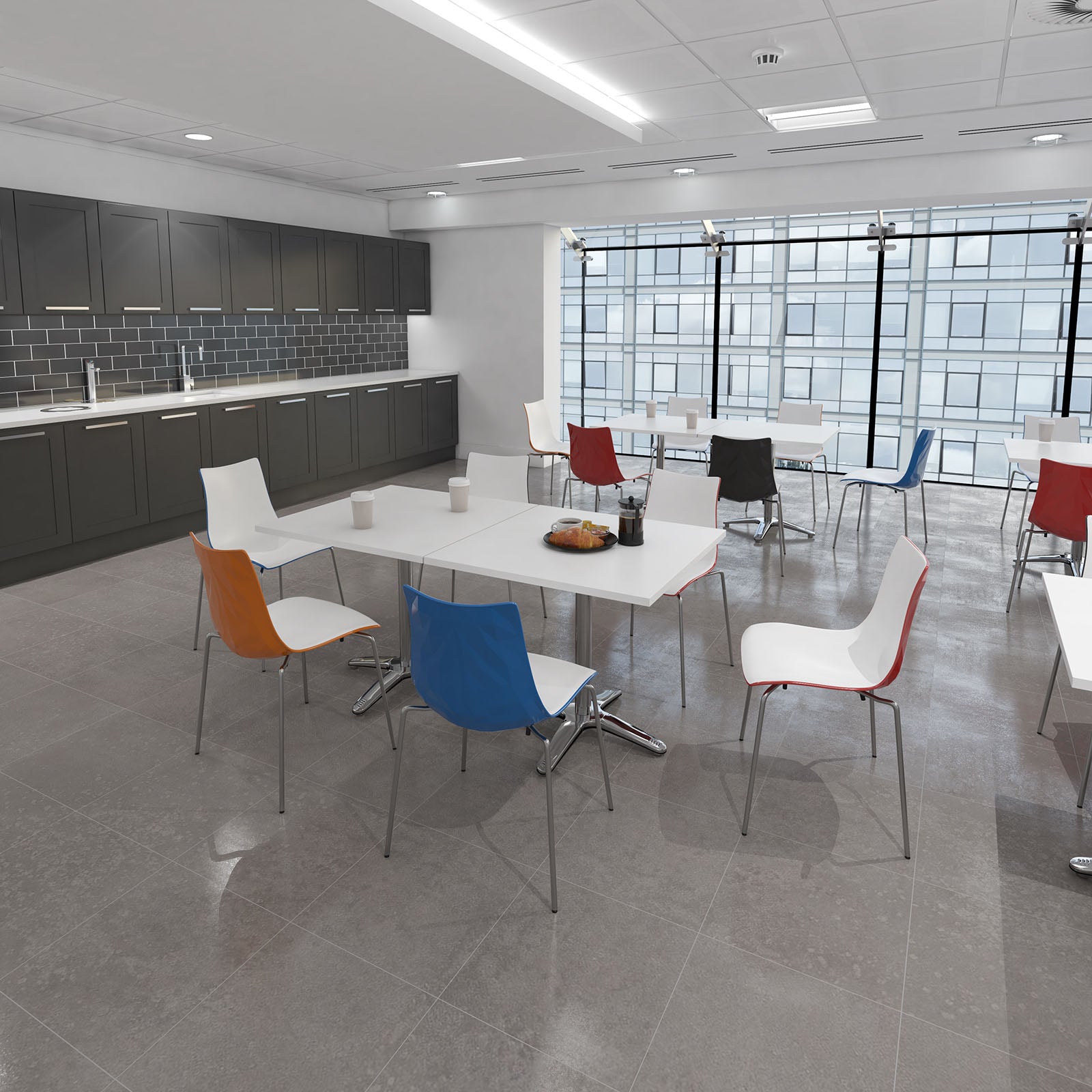 Modern office break room with colorful chairs and tables.
