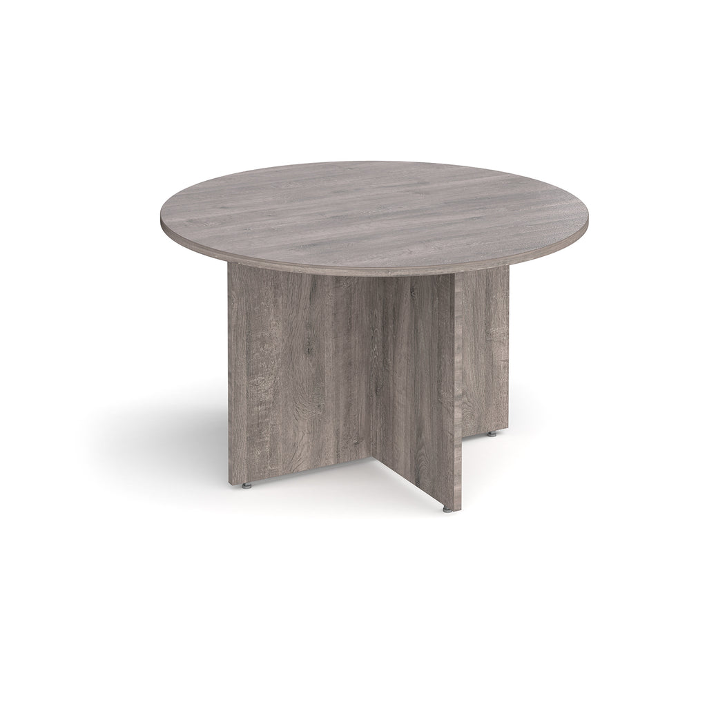 Round meeting table with a grey wood-effect finish and panel base support, shown on a white background.