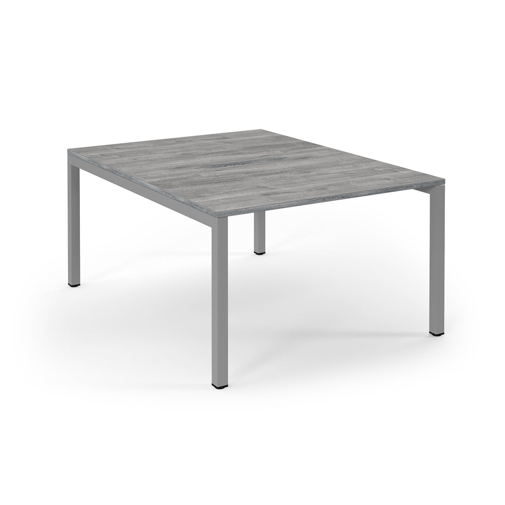 Square table with a grey wooden top and metal legs on a white background
