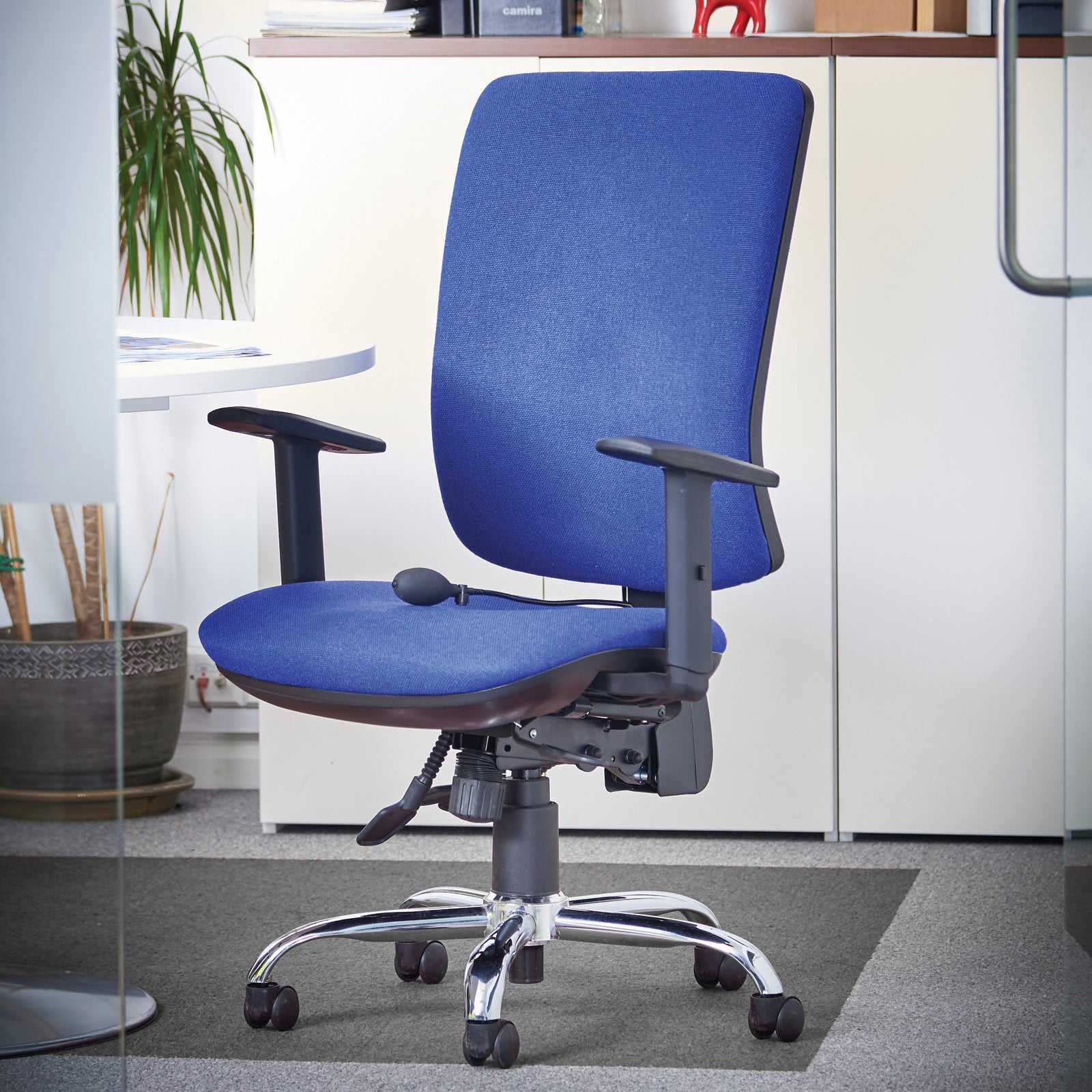 Blue office chair in an office setting with a desk and plants.