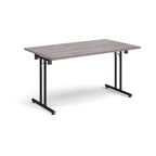 Folding table with grey wood-effect  top and black metal legs on a white background
