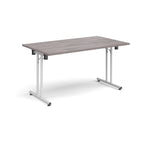 Folding table with grey wood-effect top and white metal legs on a white background