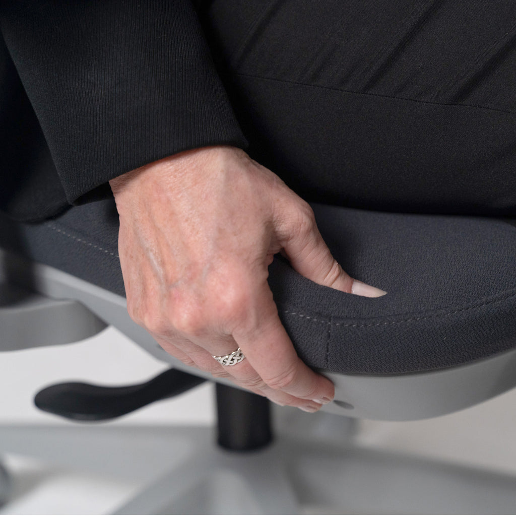 Close-up of a hand adjusting the seat depth on an ergonomic office chair, showing customised comfort and support.
