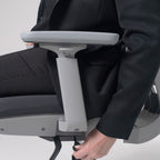 Close-up of an ergonomic office chair armrest and adjustment lever, showing easy seat height and arm support control.