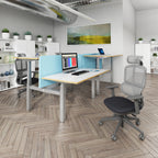 Modern office setup with desks, chairs, and a computer in a well-lit room.