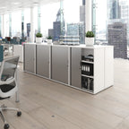 Modern office setup with a desk, chairs, and cabinets in a cityscape view.
