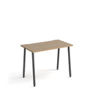 Minimalist rectangular office desk with wood-effect tabletop and angled black legs, shown against a white background.