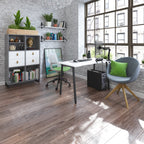 Stylish home office with white desk, storage unit, shelving, ergonomic chair, and lounge chair, set by large windows with natural light.