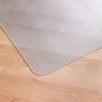 Transparent floor mat with rounded corner placed on a light wood floor, designed to protect flooring under office chairs.
