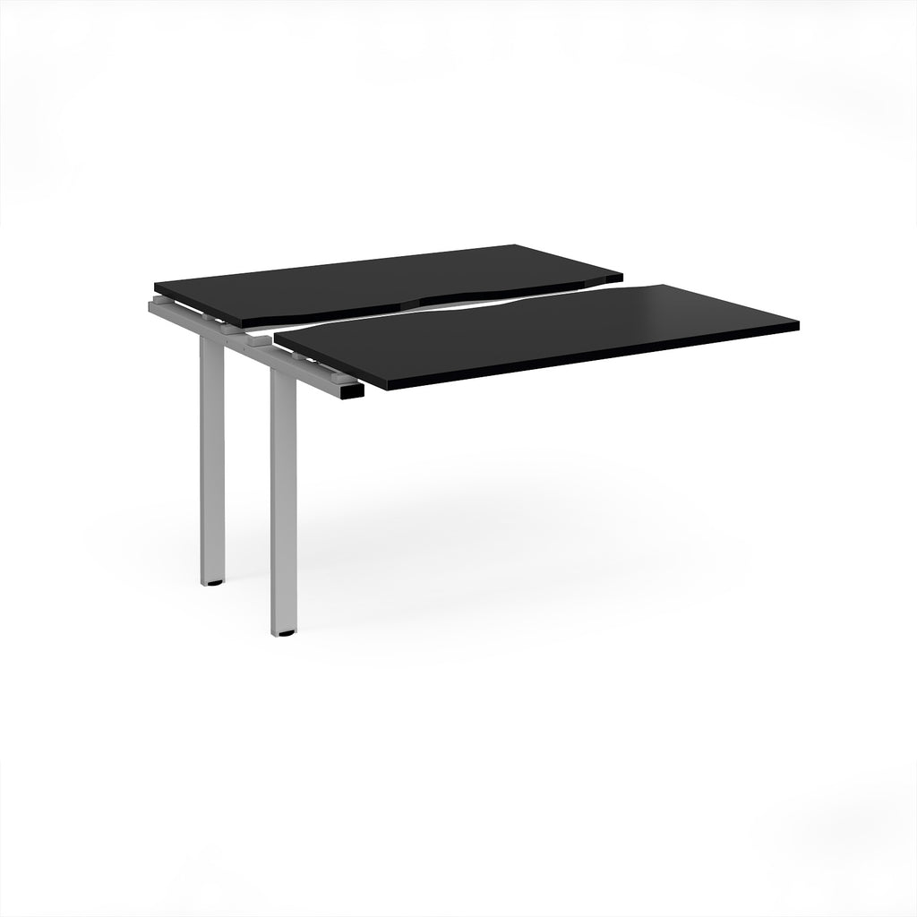 Modular bench desk add-on with a black top, integrated cable access cut-out, and silver metal legs, shown on a white background.