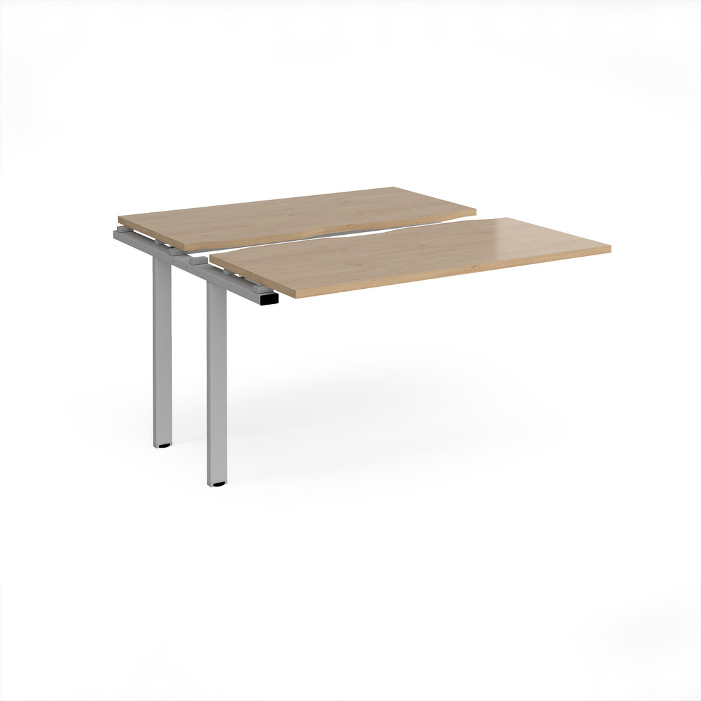 Modular bench desk add-on with a wood-effect top, integrated cable access cut-out, and  silver metal legs, shown on a white background.
