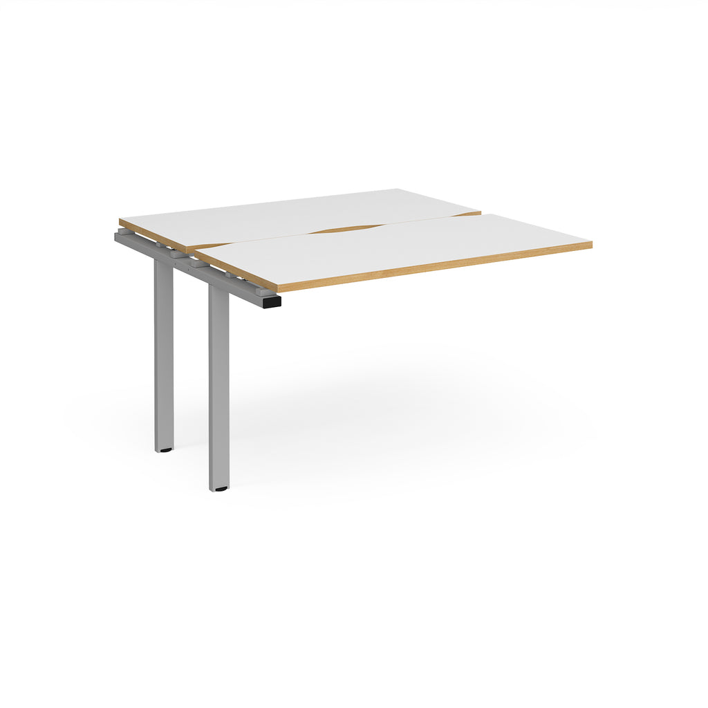 Modular bench desk add-on with white top with wood-effect edging, integrated cable access cut-out, and silver metal legs, shown on a white background.