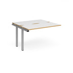 Modular bench desk add-on with white top with wood-effect edging, integrated cable access cut-out, and silver metal legs, shown on a white background.