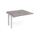 Modular bench desk add-on with a grey wood-effect top, integrated cable access cut-out, and white metal legs, shown on a white background.