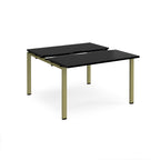 Two-person back-to-back office desk with black worktops and green metal legs, shown against a white background.