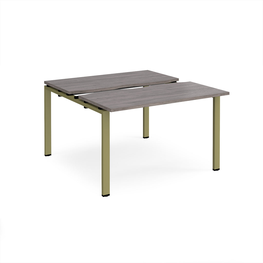 Two-person back-to-back office desk with grey wood-effect worktops and green metal legs, shown against a white background.