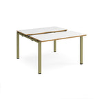 Two-person back-to-back office desk with white worktops, oak-effect edging, and green metal legs, shown against a white background.