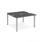 Two-person back-to-back office desk with grey worktops and silver metal legs, shown against a white background.