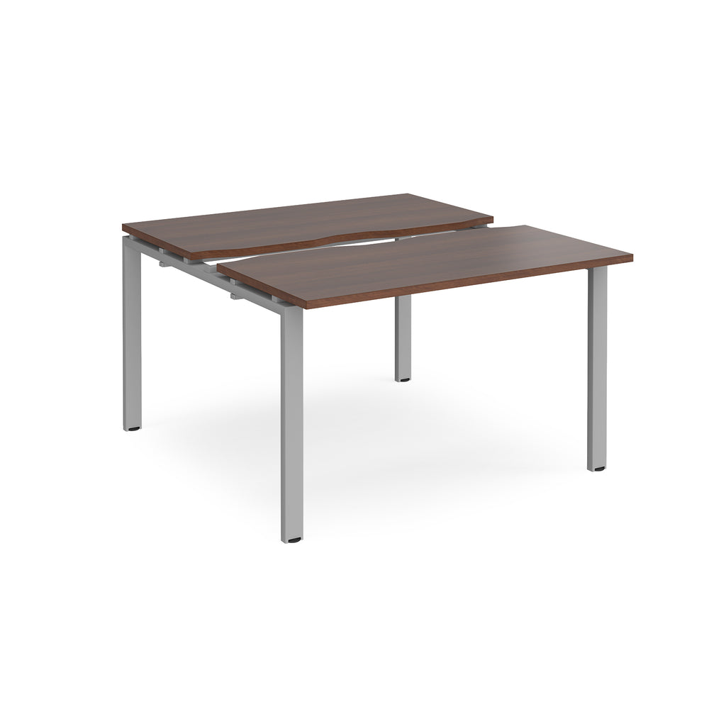 Two-person back-to-back office desk with dark wood-effect worktops and silver metal legs, shown against a white background.