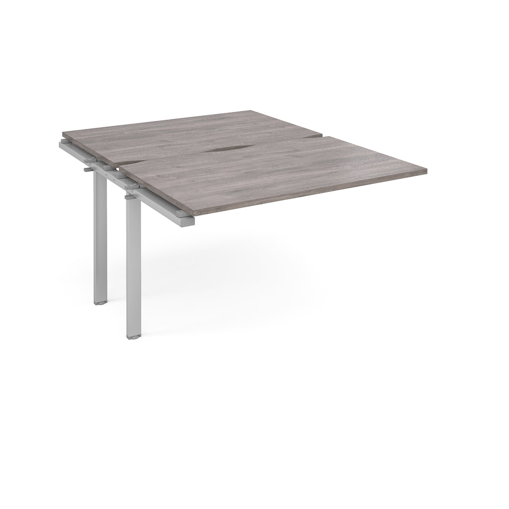 Large modular bench desk add-on with a grey wood-effect top and silver metal legs, shown on a white background.