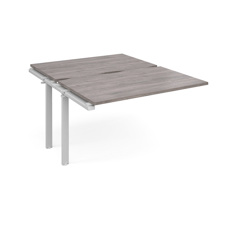 Large modular bench desk add-on with a grey wood-effect top and white metal legs, shown on a white background.