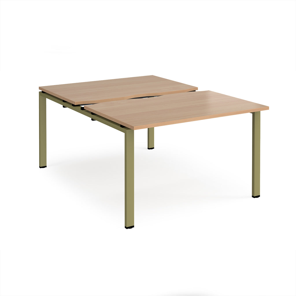 Large modular bench desk with a wood-effect top, integrated cable access cut-outs, and green metal legs, shown on a white background.