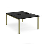 Large modular bench desk with a black worktop, integrated cable access cut-outs, and green metal legs, shown on a white background.