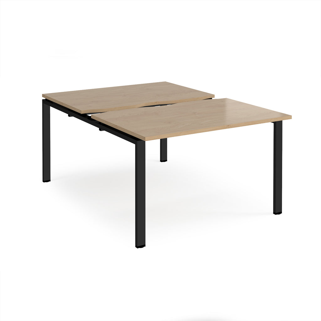 Large modular bench desk with a wood-effect top, integrated cable access cut-out, and black metal legs, shown on a white background.