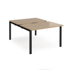 Large modular bench desk with a wood-effect top, integrated cable access cut-out, and black metal legs, shown on a white background.