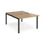 Large modular bench desk with a wood-effect top, integrated cable access cut-out, and black metal legs, shown on a white background.