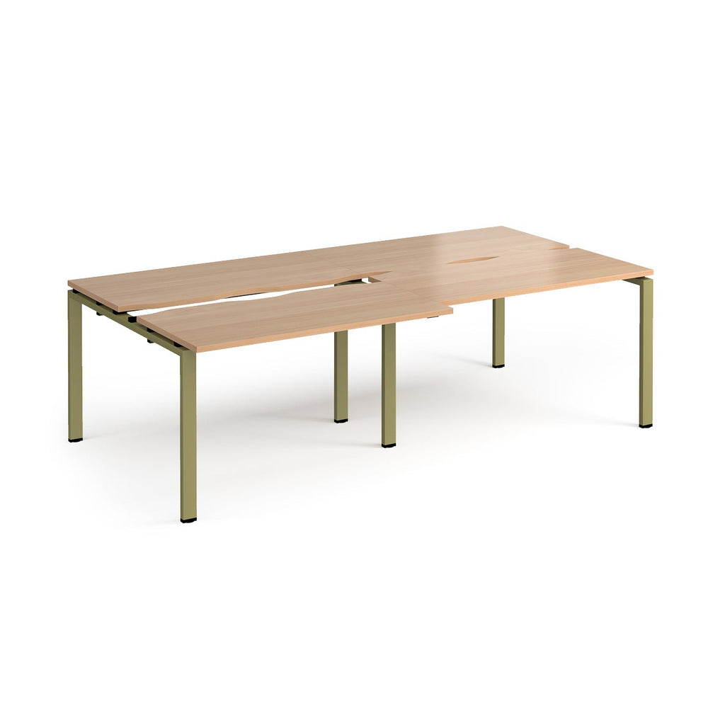 Large modular bench desk with a wood-effect top, integrated cable access cut-outs, and green metal legs, shown on a white background.