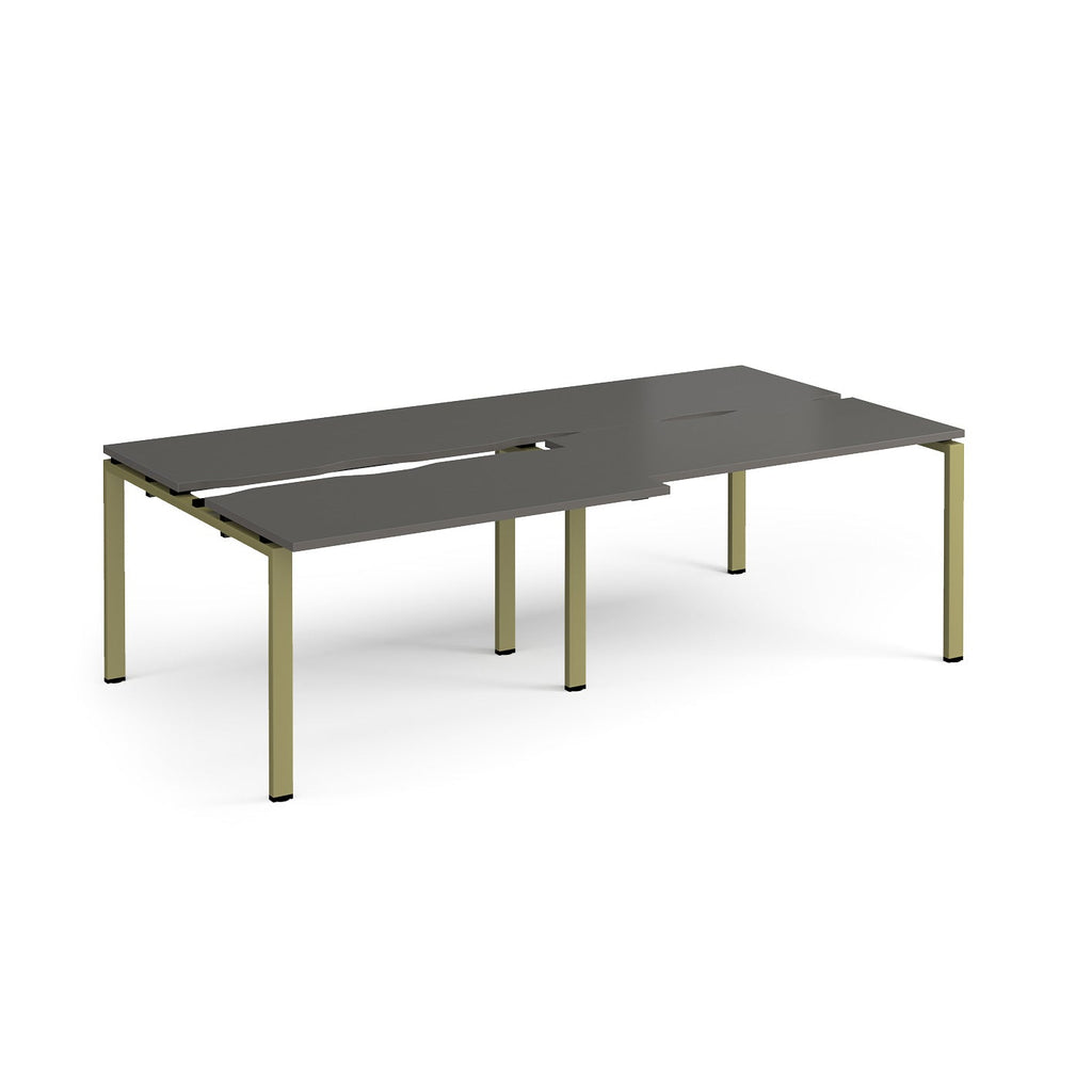 Large modular bench desk with a grey top, integrated cable access cut-outs, and green metal legs, shown on a white background.