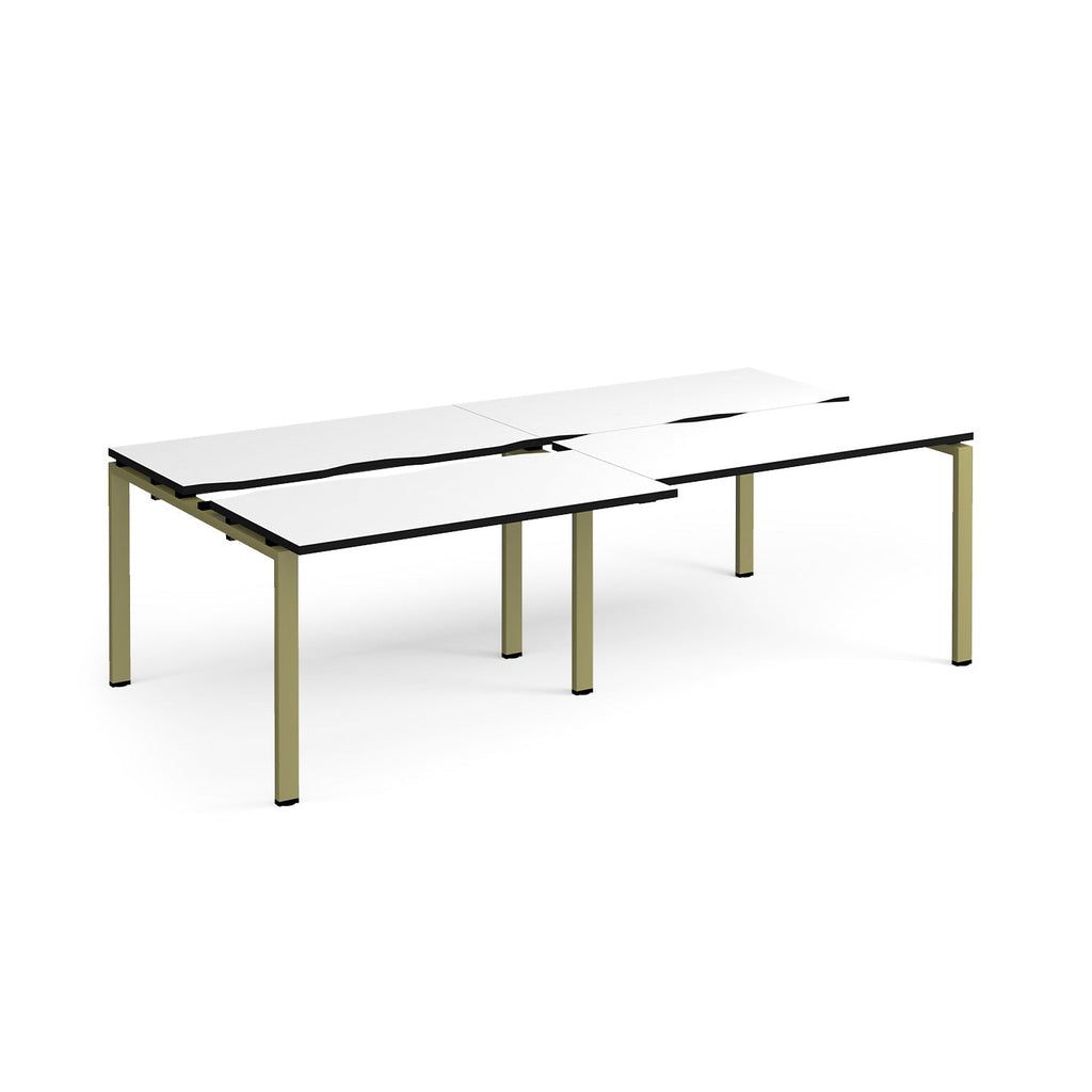 Large modular bench desk with a white worktop, contrasting black edge detail, integrated cable access cut-outs, and green metal legs, shown on a white background.