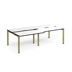 Large modular bench desk with a white worktop, contrasting black edge detail, integrated cable access cut-outs, and green metal legs, shown on a white background.