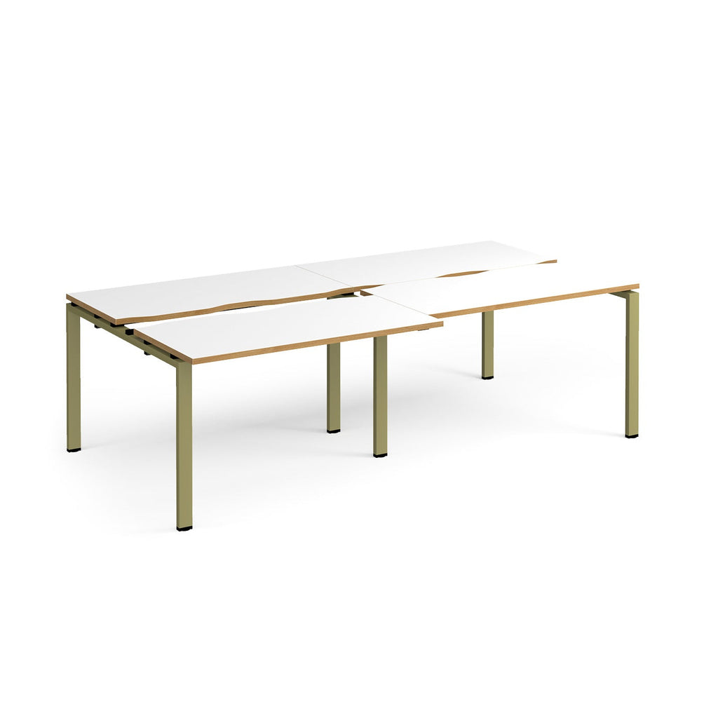 Large modular bench desk with white panels and wood-effect edging, integrated cable access cut-outs, and green metal legs, shown on a white background.