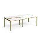 Large modular bench desk with white panels and wood-effect edging, integrated cable access cut-outs, and green metal legs, shown on a white background.