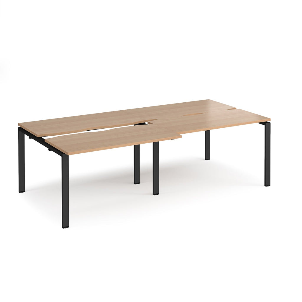 Large modular bench desk with a wood-effect top, integrated cable access cut-outs, and black metal legs, shown on a white background.