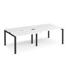 Large modular bench desk with a white worktop, integrated cable access cut-outs, and black metal legs, shown on a white background.