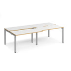 Large modular bench desk with white panels and wood-effect edging, integrated cable access cut-outs, and silver metal legs, shown on a white background.