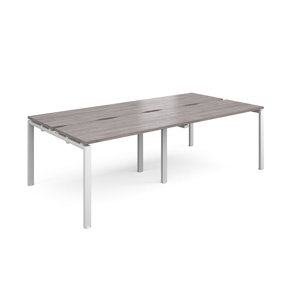 Large modular bench desk with a grey wood-effect top, integrated cable access slots, and white metal legs, shown on a white background.