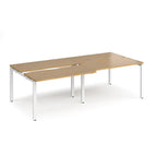 Large modular bench desk with a oak wood-effect top, integrated cable access cut-outs, and white metal legs, shown on a white background.